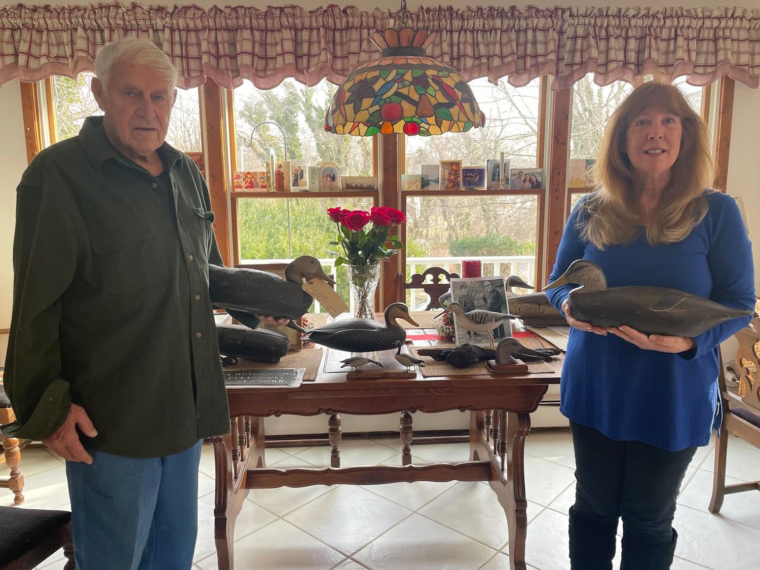 LIDCA past president Dick Richardson and Paul Bigelow’s granddaughter, Denise Valenti, stand in front of decoys, including some from her great-grandfather and grandfather, promoting their upcoming shows and anniversary.